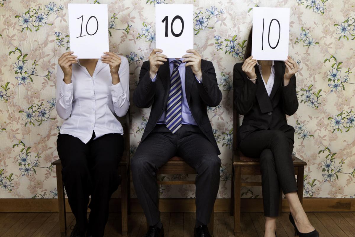 Three people holding "perfect 10" signs