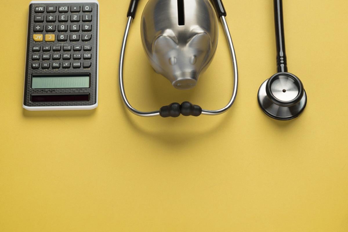 Calculator, stethoscope and piggy bank
