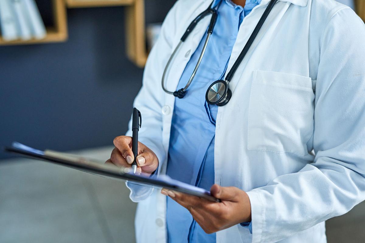 Health care professional writing on a clip board