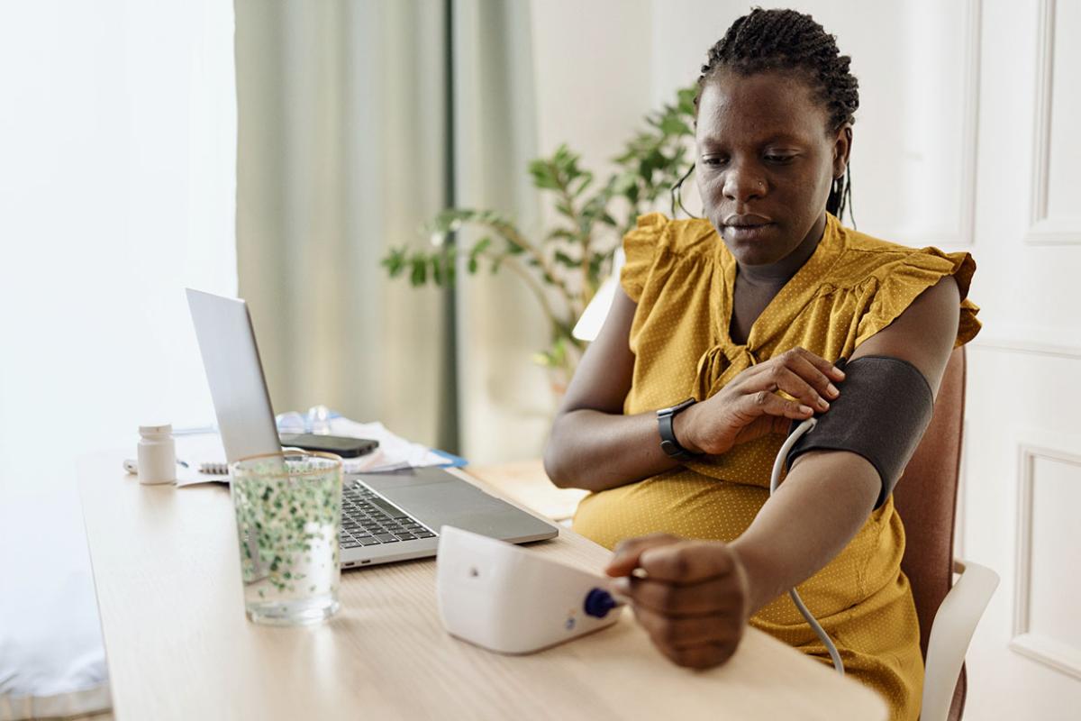 Pregnant woman checking blood pressure at home