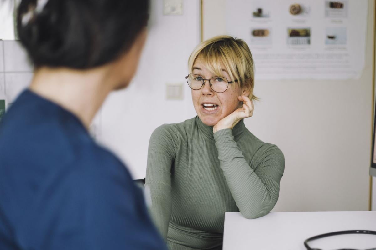 Patient leaning on elbow while in discussion