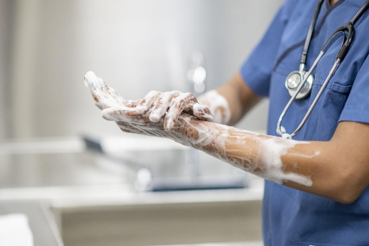 Physician scrubbing hands