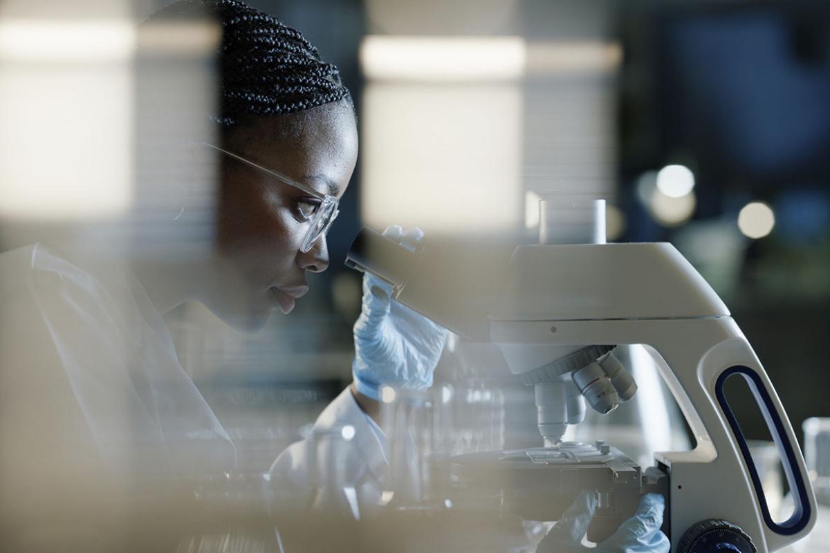 Scientist in a lab using a microscope for analysis
