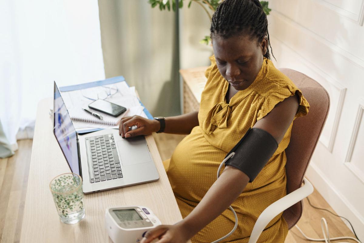 Pregnant woman checks blood pressure at home