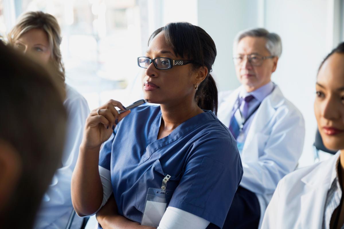 A diverse group of physicians listens to a seminar for CME credit.