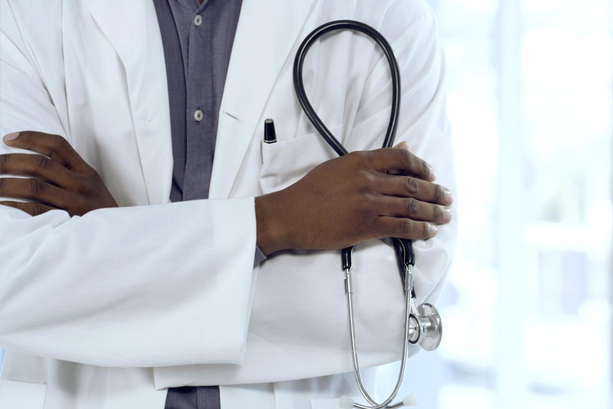 Why We Fight Scope pillar: Physician with arms crossed, holding a stethoscope