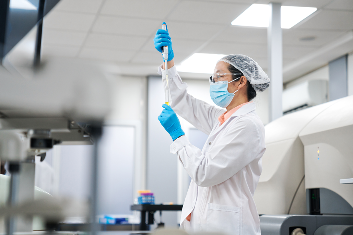 Scientist pipetting chemical in test tube at laboratory 